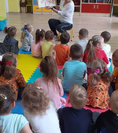 dzieci przedszkolne słuchają czytanej bajki